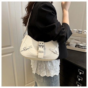 Detail of white crocodile pattern baguette bag with silver buckle worn on shoulder
