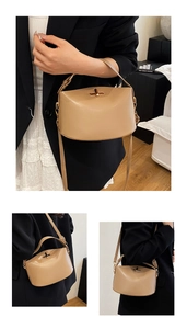 Close-up of beige PU leather handbag with golden twist lock and detachable shoulder strap