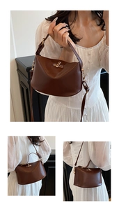 Detail of dark brown leather handbag featuring a polished gold twist-lock and shoulder strap