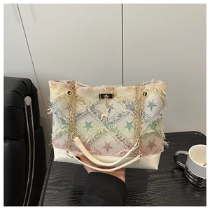 Detail of star-quilted canvas tote with rainbow gradient, fringe edges, and chain strap