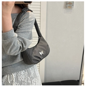 Detailed macro view of dark grey fabric hobo bag with silver butterfly metal buckle