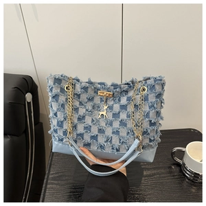 Detail of denim crossbody bag with star gradient, frayed edges and gold deer charm