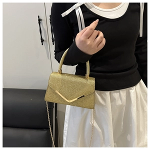Detail of gold sequin evening bag featuring V-shaped metal trim and chain strap