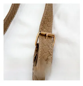 Detail of tan woven texture shoulder strap with premium golden adjustable buckle
