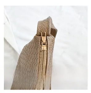 Detail of smooth gold zipper and woven brown leather texture on French style crossbody bag