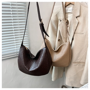 Detail of woven crescent hobo bags in dark coffee and apricot with leather straps