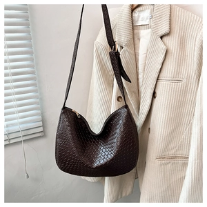 Detail of dark brown woven texture on a minimalist crescent-shaped hobo bag for women