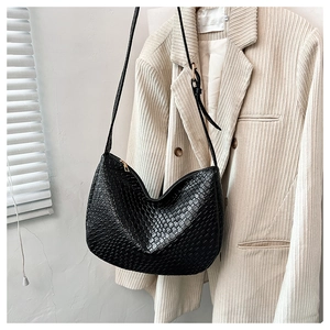 Close-up of woven black faux leather hobo bag with gold zipper and stylish crescent shape