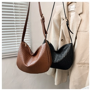 Close-up of intricate woven texture on hobo bags in classic brown and black colors