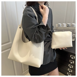 Détail du sac fourre-tout crème avec texture en cuir grainé et petite pochette assortie