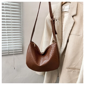 Close-up of brown woven leather hobo bag with gold zipper and adjustable strap detail