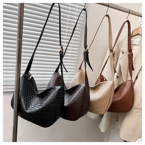 Detail of woven crescent Hobo bags in black brown cream and caramel leather texture