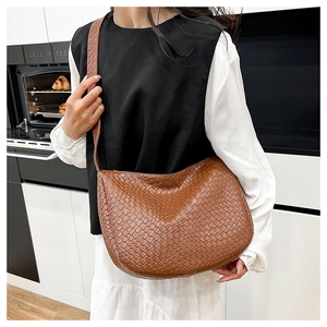 Close-up of brown woven leather hobo bag showing intricate Intrecciato texture and style