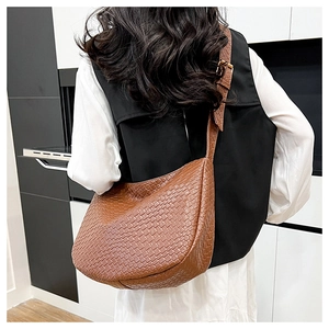 Detailed view of brown woven PU leather texture and adjustable strap on hobo shoulder bag