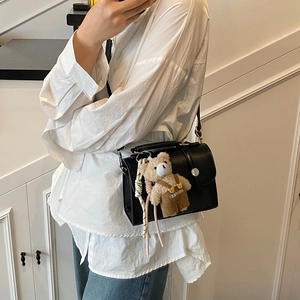 Fashionable black crossbody box bag with a silver buckle and cute bear pendant accessory