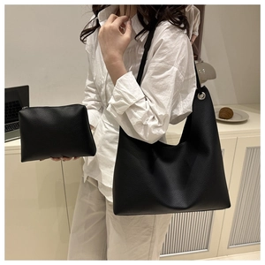 Détails du sac cabas minimaliste noir grainé avec pochette assortie sur un bureau