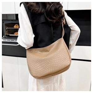 Close-up of light brown woven texture shoulder bag with modern minimalist PU leather design