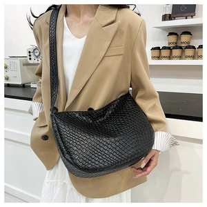 Close-up of black woven leather texture and hobo style shoulder strap details