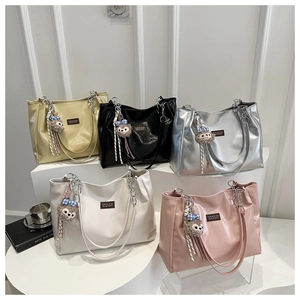 Detailed view of colorful tote bags with metal chain straps and plush bear charms