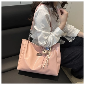 Pink oversized tote bag detail with metal chain strap and cute plush monkey charm