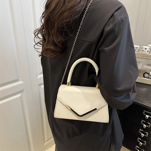 White sequin handbag with gold V-metal buckle and chain strap, shown on shoulder