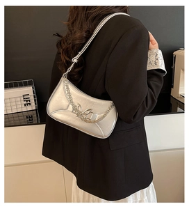 Silver hobo shoulder bag with metal butterfly and chain detail on female model