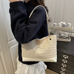 Straw tote bag with white leather base and gold deer charm for summer vacations
