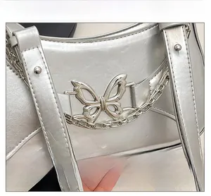 Macro shot of silver metallic bag featuring butterfly hardware and elegant chain detail