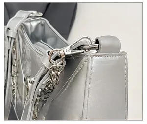 Detail shot of silver metallic leather texture with premium hardware hook and chain link