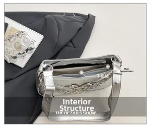 Detail view of silver shoulder bag interior featuring main zip pocket and phone compartment
