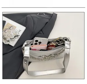 Detail showing spacious interior of the silver shoulder bag with phone and wallet