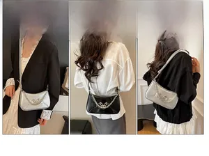 Détail du sac sous l'aisselle tendance avec finition brillante et papillon en métal décoratif