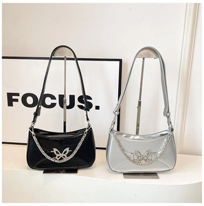 Detail of stylish silver and black shoulder bags with metal butterfly buckle and chain