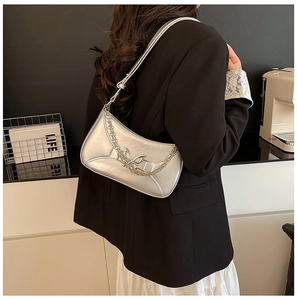 Vue détaillée du sac à bandoulière argenté avec boucle papillon métallique et chaîne élégante