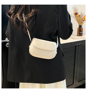 Vue détaillée d'un sac selle blanc minimaliste en cuir lisse avec fermeture à rabat