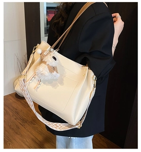 Detail of off-white tote bag featuring lychee texture PU leather and bohemian strap