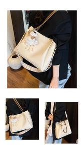 Detail of off-white tote bag with embroidered strap and cute plush sheep charm
