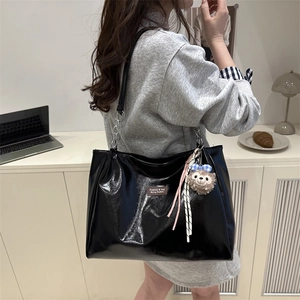 Large capacity black patent leather tote bag with stylish chain strap and plush charm