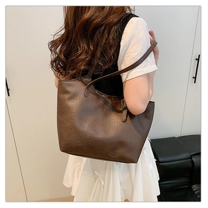 Macro shot of dark brown soft leather tote bag showing detailed texture and stitching