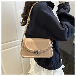 French style apricot underarm bag with silver heart buckle shown on model shoulder