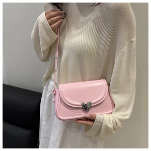 Detail of pink PU leather crossbody bag featuring a silver heart-shaped metal clasp