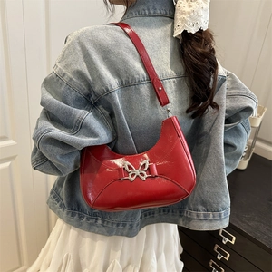 Sac à bandoulière rouge en forme de croissant avec boucle papillon en métal