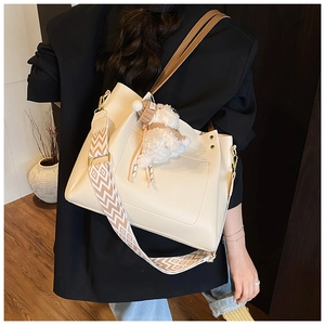 Detail of cream tote bag with textured leather and patterned wide shoulder strap