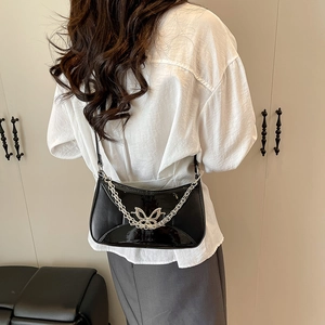 Sac croissant chic en cuir verni noir avec chaîne papillon argentée et détails métalliques