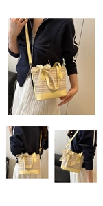 Detailed straw bucket bag with yellow leather trim and elegant white lace bow detail