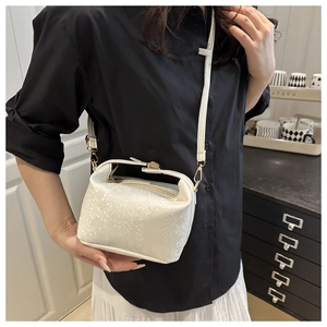 Detail of white snake-embossed crossbody bag paired with a minimalist daily outfit