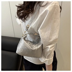 Detail of silver snake-patterned handbag with metallic finish and adjustable shoulder strap