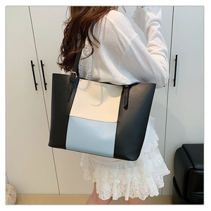 Close-up of color-block tote bag showing premium matte texture and gold hardware details