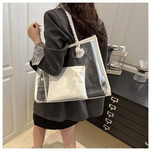Detail view of transparent PVC tote bag with white inner pouch and rope shoulder strap