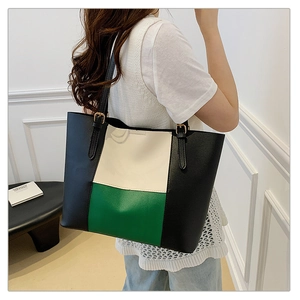 Detail of adjustable shoulder strap with gold buckle on tri-color leather tote bag